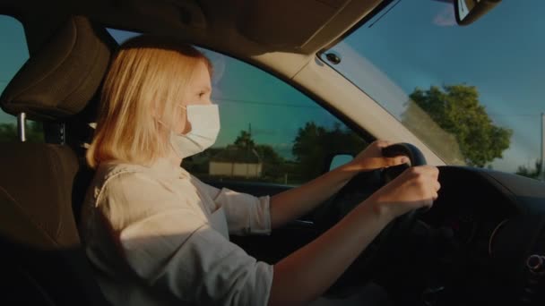 Mujer enmascarada al volante de un coche — Vídeo de stock