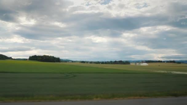 Paisaje rural en Noruega - desde la ventana se pueden ver campos donde se encuentran montones de paja después de la cosecha — Vídeo de stock