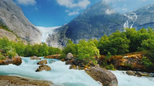 The Norwegian landscape is a rugged river, mountains and a glacier on top. The famous Briksdal Glacier — Stock Video