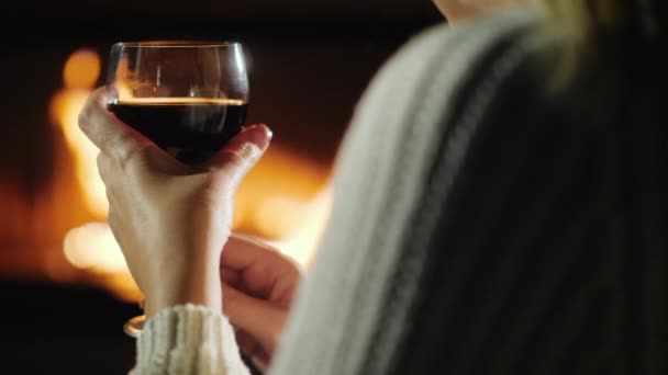 Kéz egy pohár bor egy nő, aki pihent a kandalló — Stock videók