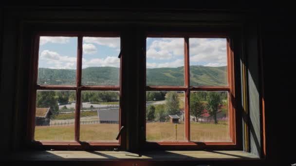 View through the old window of a wooden house to the picturesque nature of Norway — Stock Video