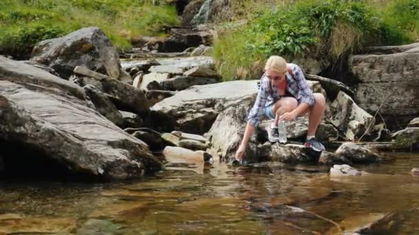 Žena pije čistou vodu z horského pramene v Norsku — Stock video