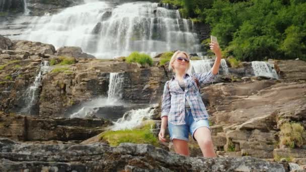 Femme se photographie sur le fondla plus haute cascade en Norvège. Vue arrière — Video