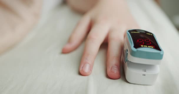 Монитор сердечного ритма на пальце ребенка измеряет пульс и насыщение крови кислородом — стоковое видео
