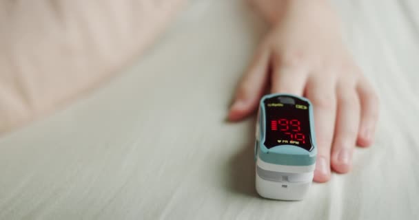 Childs ruku s monitorem tepové frekvence na prstu, měří puls a nasycení kyslíkem v krvi — Stock video