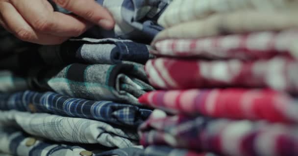 A férfiak a ruhákat a polcon rendezgetik. — Stock videók