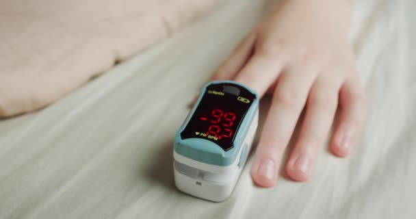 Рука ребенка с монитором сердечного ритма на пальце, измеряет пульс и насыщение крови кислородом — стоковое видео
