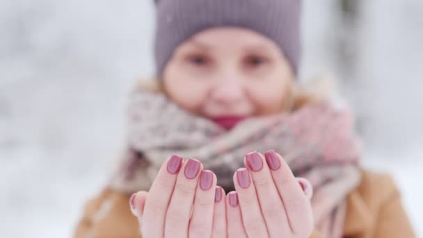 Potret seorang wanita yang menangkap kepingan salju, ketajaman di ujung jarinya — Stok Video