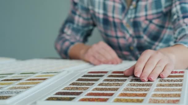 Una mano de mujer en un palet con muestras de decoración. Los diseñadores trabajan — Vídeo de stock