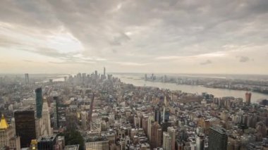 New York 'ta gün batımı, gecenin içine gün batımı, bulutlar şehrin üzerinde dramatik bir şekilde yüzüyor. Hava genişliğindeki video 4k zaman ayarlı