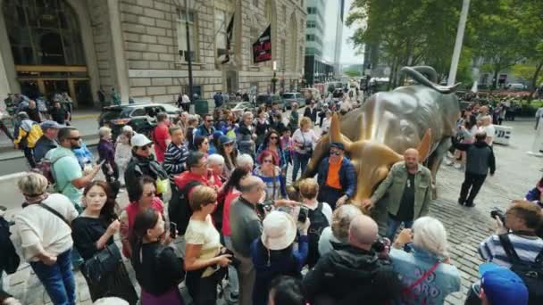 Nueva York, Estados Unidos, octubre de 2018: Mucha gente intenta tomar fotos junto a la estatua de un toro de carga — Vídeo de stock