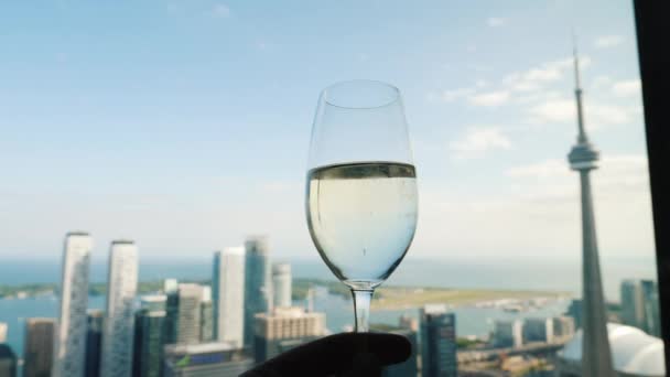 Toronto, Ontaroi, Canada, luglio 2019: Mano con un bicchiere di vino sullo sfondo della finestra dove è visibile la famosa CN Tower di Toronto — Video Stock