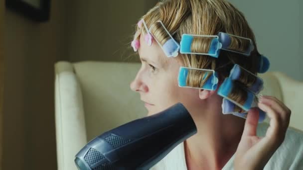 Middle aged caucasian woman dries hair dry — Stock Video