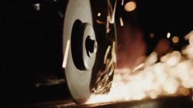 Yavaş çekim: Kaynakçı elle kullanılan güç araçlarıyla metaldeki dikişleri temizler.