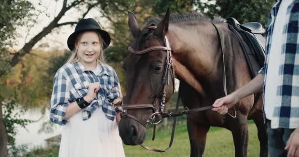 Забавная девушка на фотосессии с лошадью. Зеленый туризм на ранчо — стоковое видео