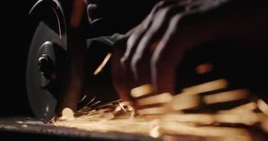 Kaynakçı kaynaklara elektronik bir aletle dokunur, kıvılcımlar yanlardan uçar.