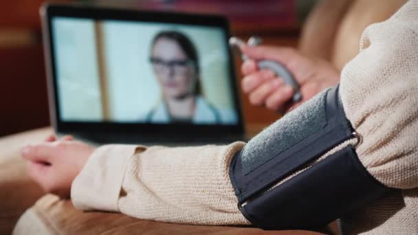 Senior woman Consults doctor via webcam, measures blood pressure — Stock video