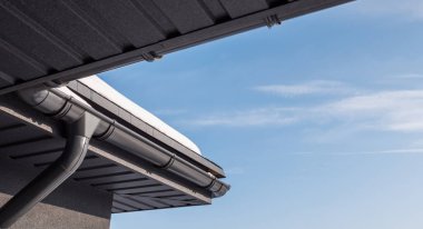 Çatının köşesinde drenaj sistemi var, çatıda kar var.