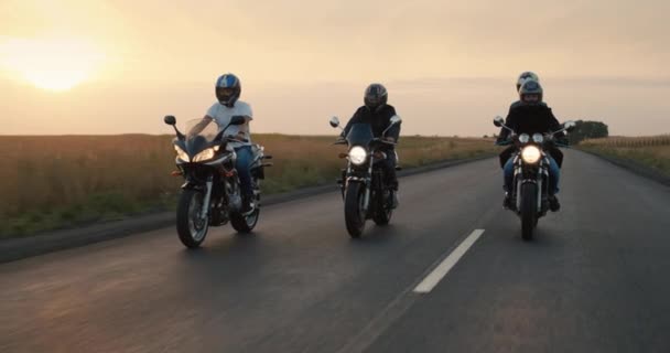 Um grupo de motociclistas anda na estrada à noite ao pôr-do-sol — Vídeo de Stock