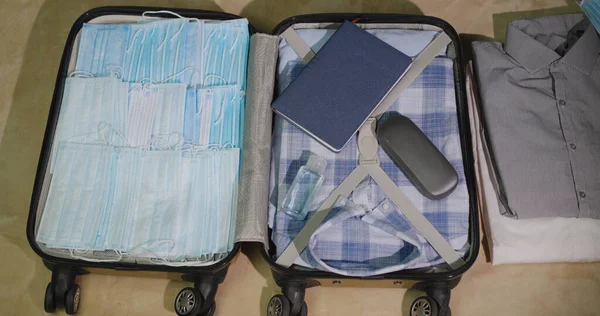Sebuah koper dengan hal-hal dan mungkin masker pelindung. Paranoid mengumpulkan hal-hal pada perjalanan bisnis — Stok Foto