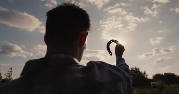 En ung mand ser på den smedede i sin hånd-symbol på held og lykke – Stock-video