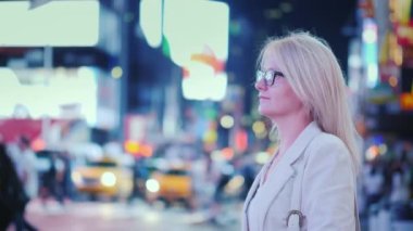 İş kadını New York 'taki ünlü Times Meydanı' nın parlak ışıklarına hayran.