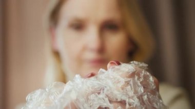 Bir kadın paketleme filminde hava kabarcıkları patlatıyor. Stres Rahatlatma Konsepti