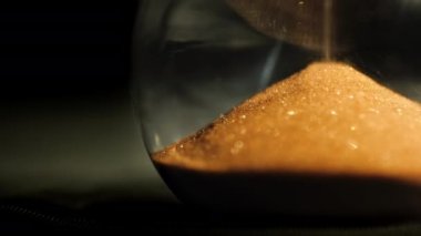 Güzel kum saati ayrıntıları, kum taneleri alttaki şişenin içine düşüyor.