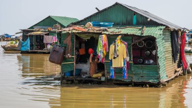 Kamboçya, Tonle Sap Gölü, Şubat 2012: Sudaki kulübesinde bir çocuk yıkanır. Khmer balıkçılarının evi ve hayatı