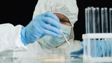 Eczacı araştırmacı kurtçuklar üzerinde deneyler yapıyor.