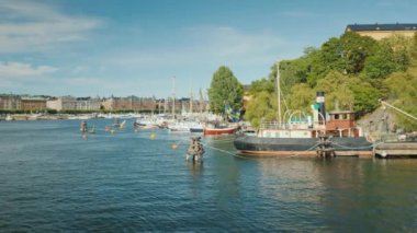 Stockholm şehri manzaralı, ön planda eski bir mavna.
