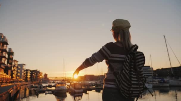Femme active se réjouit au lever du soleil sur la marina. Il court vers l'avant, lève les mains. Lever de soleil à Bergen — Video