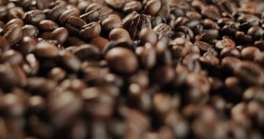 Kavrulmuş doğal kahve çekirdekleri. Saha derinliği düşük bir video. Kaydırıcı 4k atış