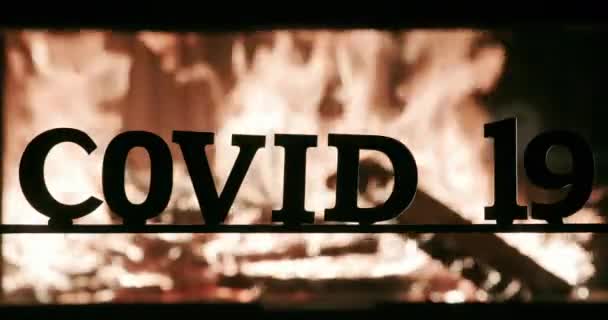 Огонь освещает буквенные силуэты слова Ковид-19 — стоковое видео