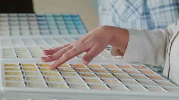 Согласно образцам материала, покупатель выбирает цвет и текстуру для ремонта дома — стоковое видео