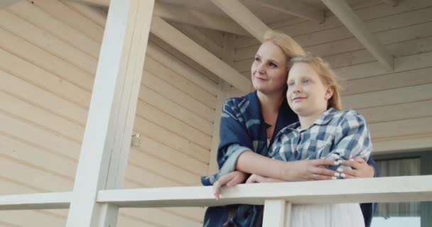 Uma mulher com um filho na varanda da sua casa de campo — Vídeo de Stock