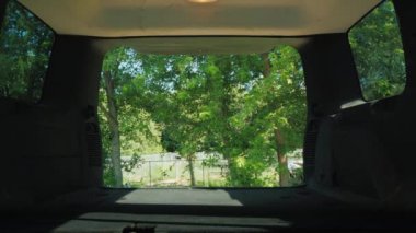 Bir adam ve bir kadın kafesleri taşımak için bir arabanın bagajına köpeklerle dolduruyorlar.