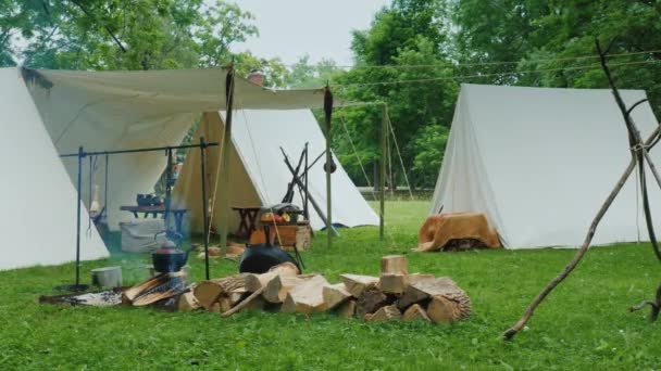 Lapangan perkemahan, di bagian depan api unggun di mana makanan disiapkan. Imitasi sebuah kamp tua tentara dari waktu perang dengan India — Stok Video
