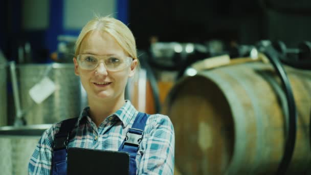 Retrato de uma assistente de laboratório mulher em óculos de proteção no fundo de barris de vinho — Vídeo de Stock