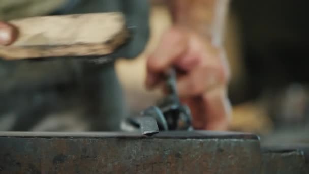 男はスケールから金属製品をきれいにします。仕事中の鍛冶屋 — ストック動画