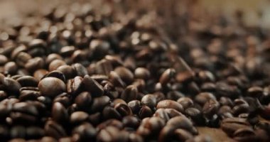 Seçilmiş kızarmış kahve çekirdekleri yığının üzerine düşer. Yavaş çekim videosu