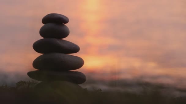 Ένα χέρι βάζει μια πέτρα στην κορυφή ενός πύργου από πέτρες. Έννοια αρμονίας και ισορροπίας — Αρχείο Βίντεο
