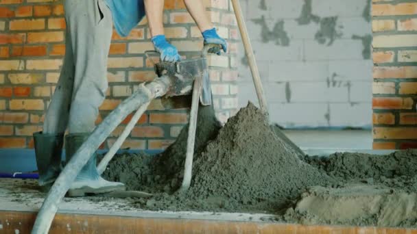 İnşaatçı zemini tamamlamak için yarı kuru havan topu koyuyor. — Stok video