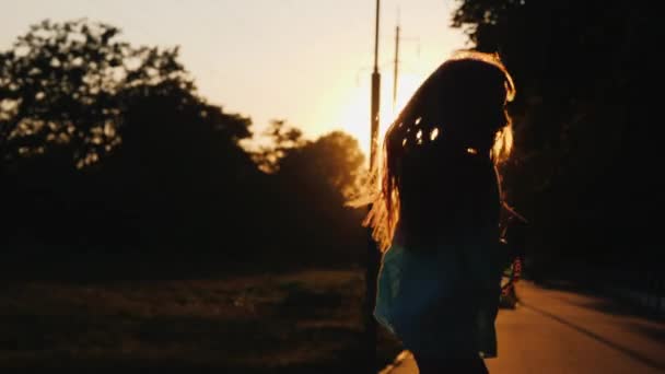 Silhouette of a girl having fun running down the alley in the rays of the setting sun — Stock Video