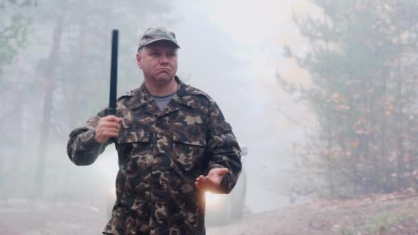 Angry man in camouflage clothing with a rubber truncheon in his hand — Stock Video