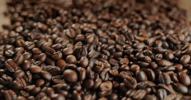 Un montón de granos de café tostados. Video con una baja profundidad de campo — Vídeos de Stock