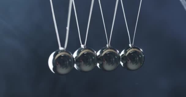 Крупный план Newtons Pendulum - металлические шары ударяются друг о друга и показывают эффект энергосбережения — стоковое видео