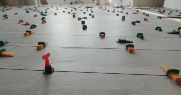 Op de vloer van het huis te zetten keramische tegels, vastgesteld door het systeem van uitlijning. Breed lensschot — Stockvideo