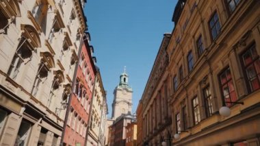 St. Nicholas - Stockholm 'deki Storkyrkan çan kulesi. Eski evlerin olduğu dar bir sokaktan bak.