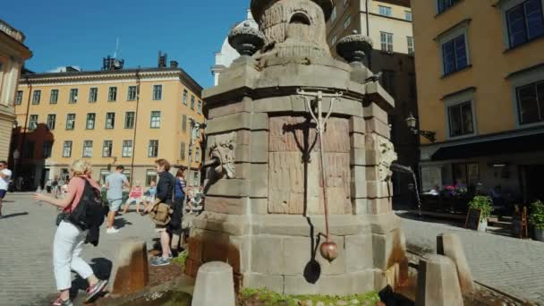 ストックホルム,スウェーデン, 2018年7月:ストックホルムの旧市街に飲料水の泉。近くの観光客が歩く、人気の休日の目的地 — ストック動画